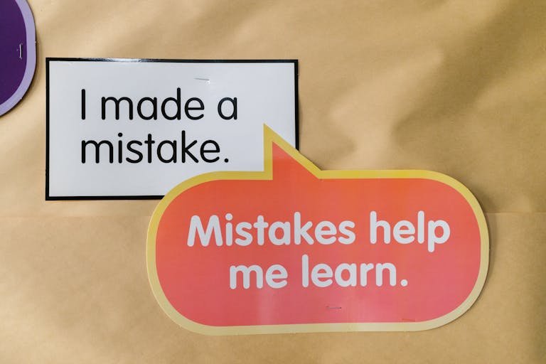 Bright square and speech bubble sign with motivational quotes about mistakes and learning.